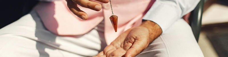 A man holding a hypnotic pendant